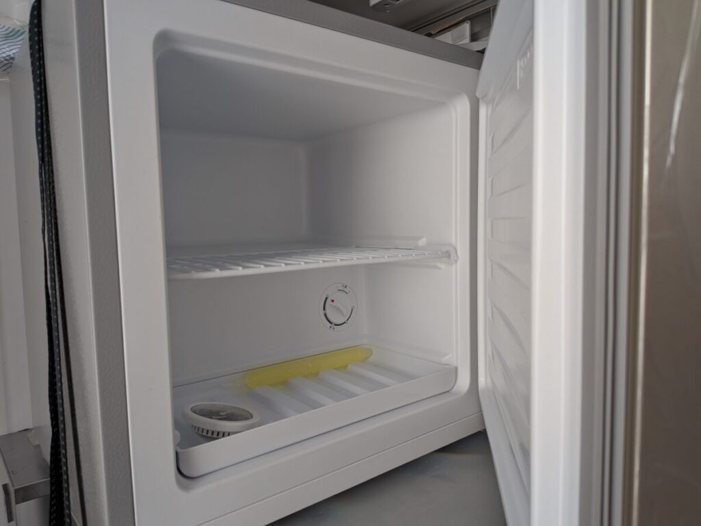 小型冷凍庫の中、棚と温度調節ダイヤルが見える