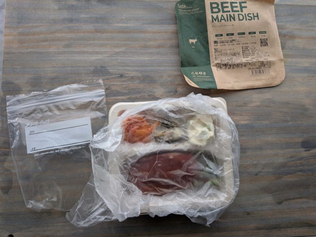 ナッシュの冷凍弁当をプレスンシールでしっかり包み、圧縮したものをナッシュの容器に戻した様子