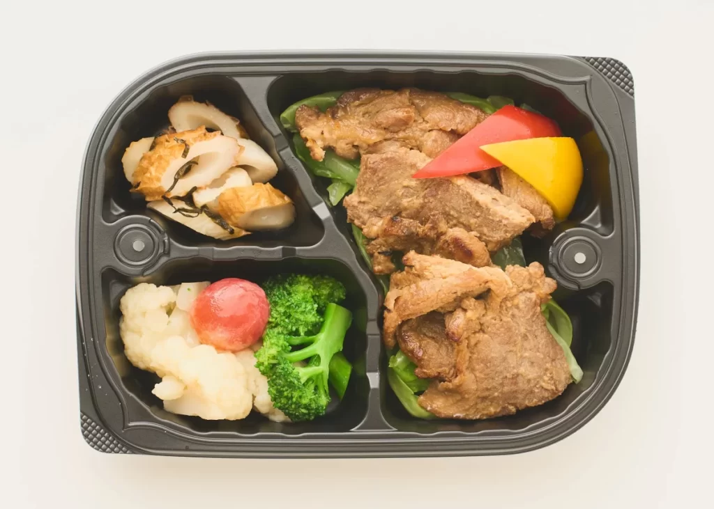 オイシエダイニングのバリュー弁当「甘み引き立つ豚肉の西京みそ焼き」。豚肉の西京みそ焼きに、温野菜バターソース、ひじきの煮物が入った210gのセット。