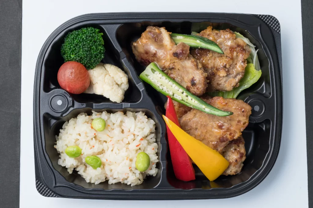 オイシエダイニングスタンダードの「甘み引き立つ豚肉の西京みそ焼き豚」肩ロースの西京みそ焼き、枝豆ピラフ、温野菜(ブロッコリー・カリフラワー・ミニトマト・パプリカ)が入った275gの冷凍弁当。