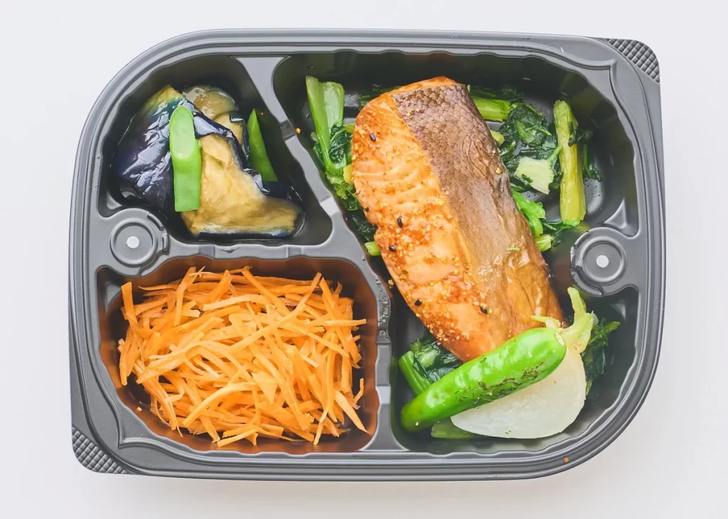 唐辛子と山椒がきいた鮭七味焼きの弁当。鮭の主菜に、なすの煮浸し・人参サラダなどの副菜が入ったバリューカテゴリーのメニュー