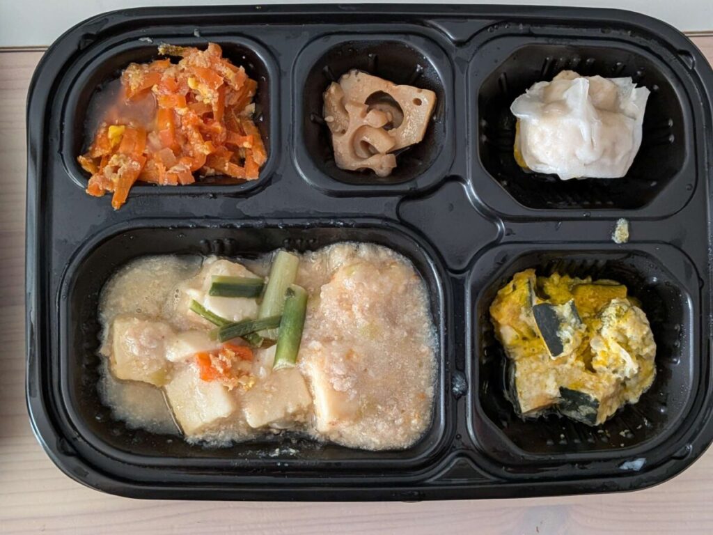 ワタミ宅食ダイレクト五菜「鍋仕込みの麻婆豆腐」セット。麻婆豆腐を主菜に、にんじんしりしり、れんこん煮、焼売、かぼちゃサラダの副菜が入った全体写真。