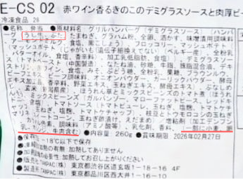 筋肉食堂DELIの食品表示ラベルの拡大写真。赤枠で強調された原材料名には「牛肉・豚肉」の記載があるが、末尾のアレルギー表示欄（一括表示）には「豚肉」が含まれていない様子。