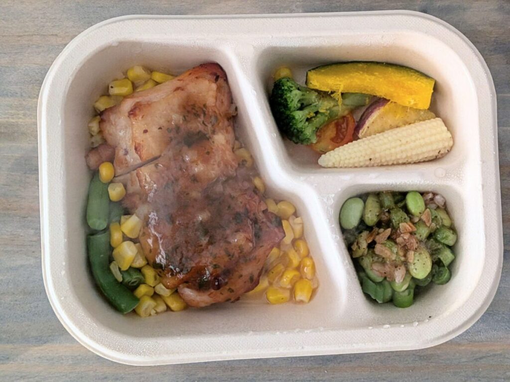 グリーンスプーンデリ弁当の香味野菜のこんがりチキンステーキとサイド枝豆ガーリックペッパーと温野菜サラダ