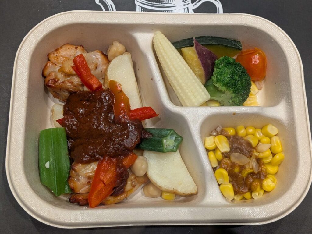 グリーンスプーンデリ弁当濃厚スパイシーケイジャンチキン、サイドはファッロとコーンのカレーと温野菜サラダ