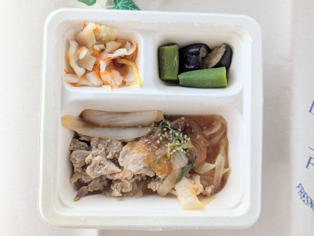 三ツ星ファーム弁当生姜焼きが温まった様子、副菜はキャベツとにんじんの浅漬けとなすのオクラの煮浸し