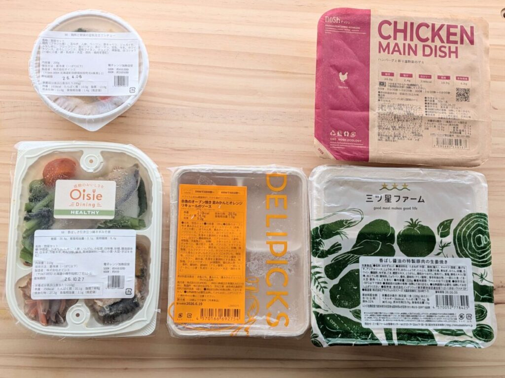 デリピックス、オイシエダイニング、三ツ星ファームの冷凍宅食弁当を横に並べた容器サイズ比較写真。