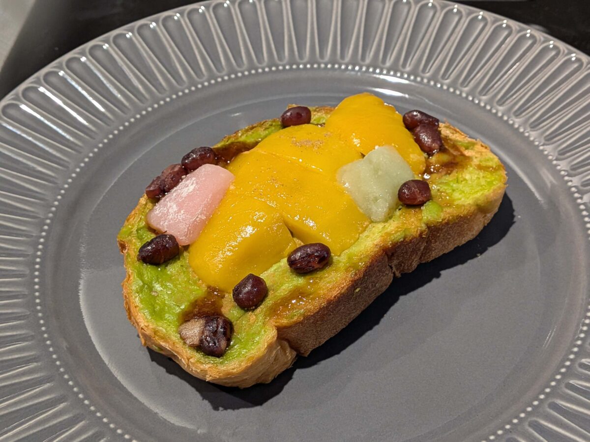 焼き上がったデリピックスのオープンサンドのマンゴーと抹茶クリーム 大納言小豆のアクセントをグレーのお皿に盛り付けた様子