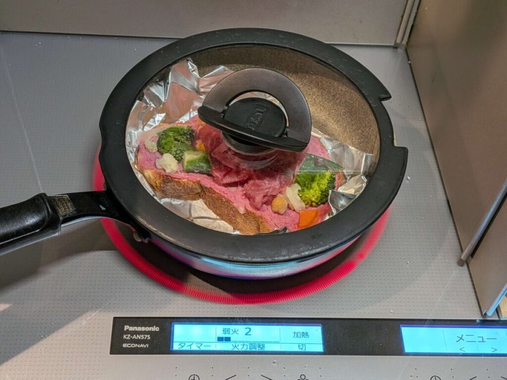 デリピックスオープンサンドをフライパンに入れ、ふたをして弱火2で加熱している様子