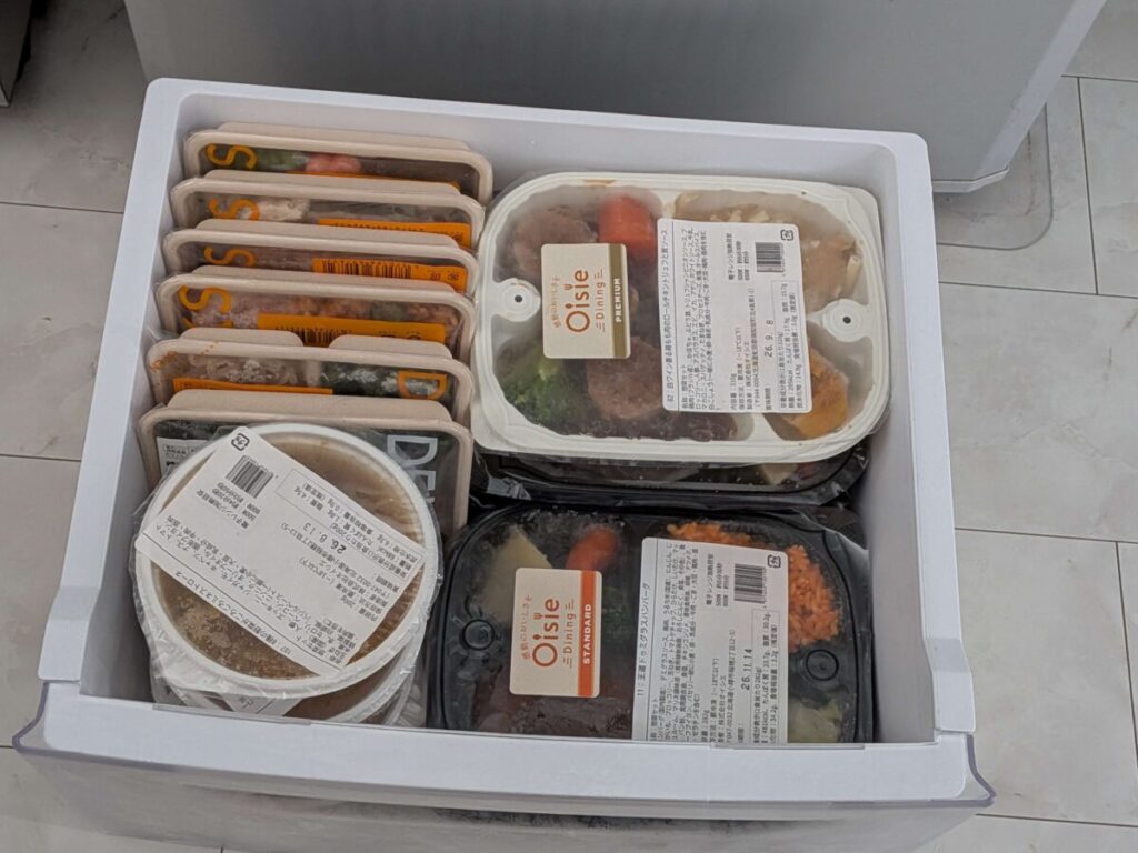 冷凍庫の引き出しに、オイシエダイニングの容器2つを平置きし、その横にナッシュとデリピックスを並べて隙間なく収納した写真。
