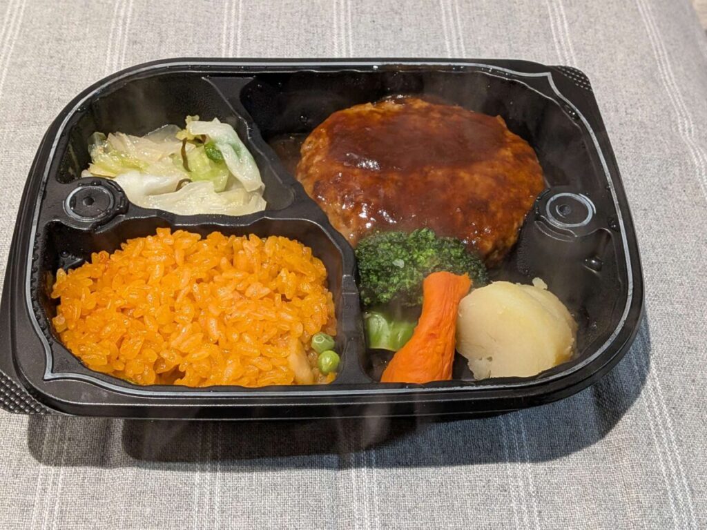 オイシエダイニングの王道ドゥミグラスハンバーグの完成写真。付け合わせはキャベツの塩昆布和えとチキンライス。