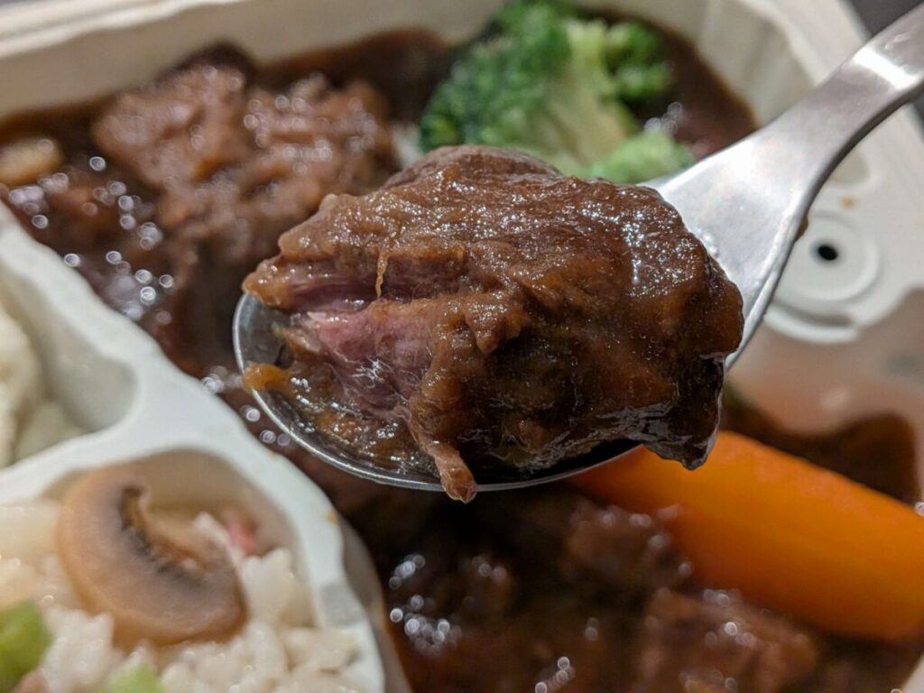 オイシエダイニングの牛タンの赤ワイン煮の牛タンをスプーンで持っているアップ写真