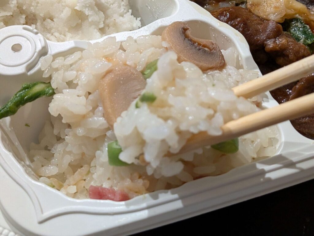 オイシエダイニングの牛タンの赤ワイン煮副菜バターライスを箸で持っているアップ写真。