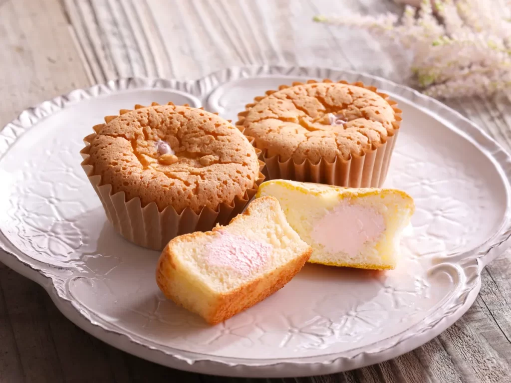 ナッシュいちごミルキークリーム カップシフォン3個が白いお皿に盛り付けられた様子。1つは半分にカットされて、いちごクリームが入っているのがわかる。