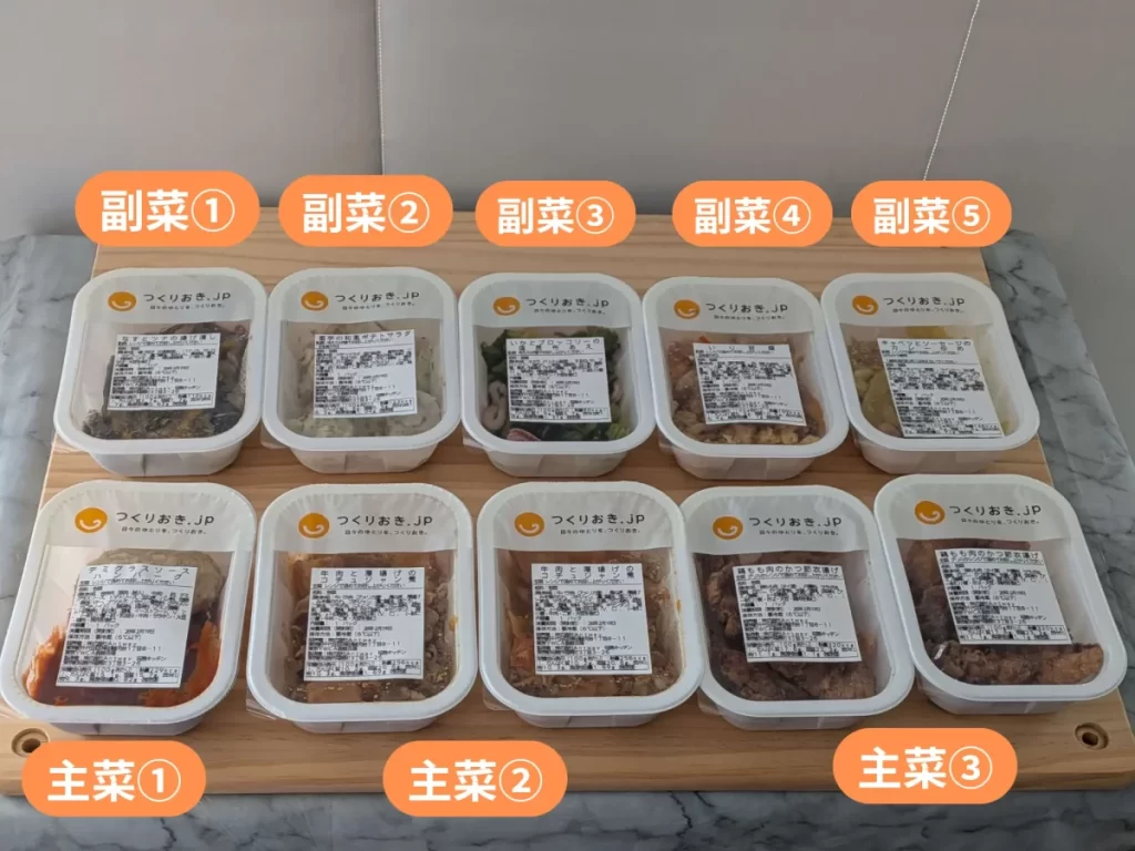 つくりおき.jp2人前の全パッケージを木のテーブルに並べた様子。