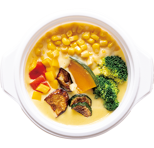 ウェルネスダイニングの甘くてなめらか コーンチャウダー。コーンスープにパプリカかぼちゃズッキーニブロッコリーなどが彩りよく入っている。